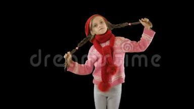 一个大约10岁和12岁的小女孩戴着一顶红色针织帽子和围巾，把她的辫子放在手里，然后游泳